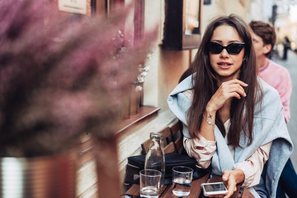 Kvinna med en Apple iphone på ett café