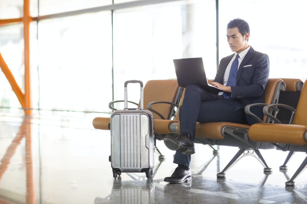 Young businessman using laptop in airport